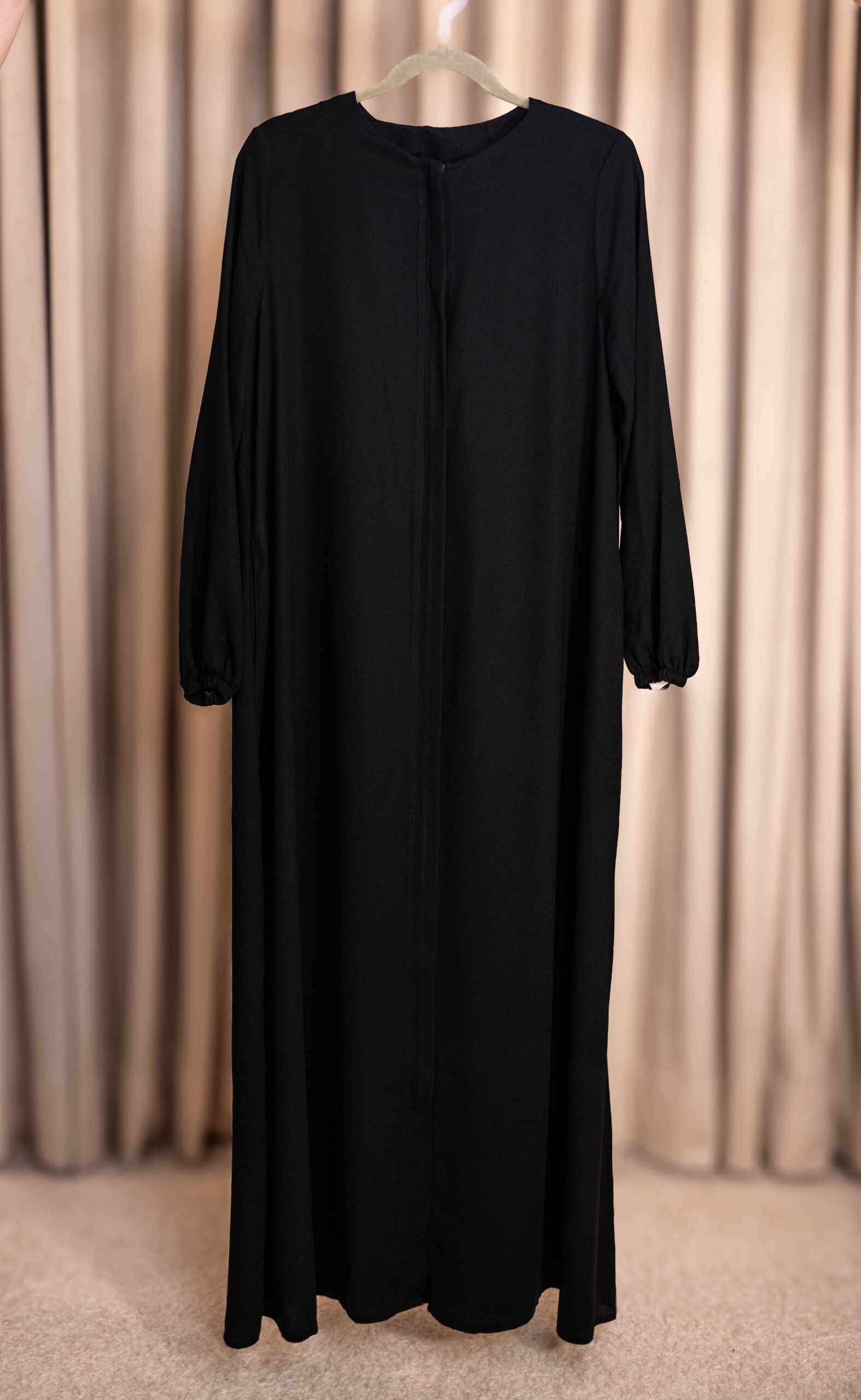 Black Selma everyday Turkish abaya in matte nida, full length on a hanger